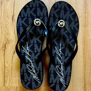 Black and grey MK flip flops